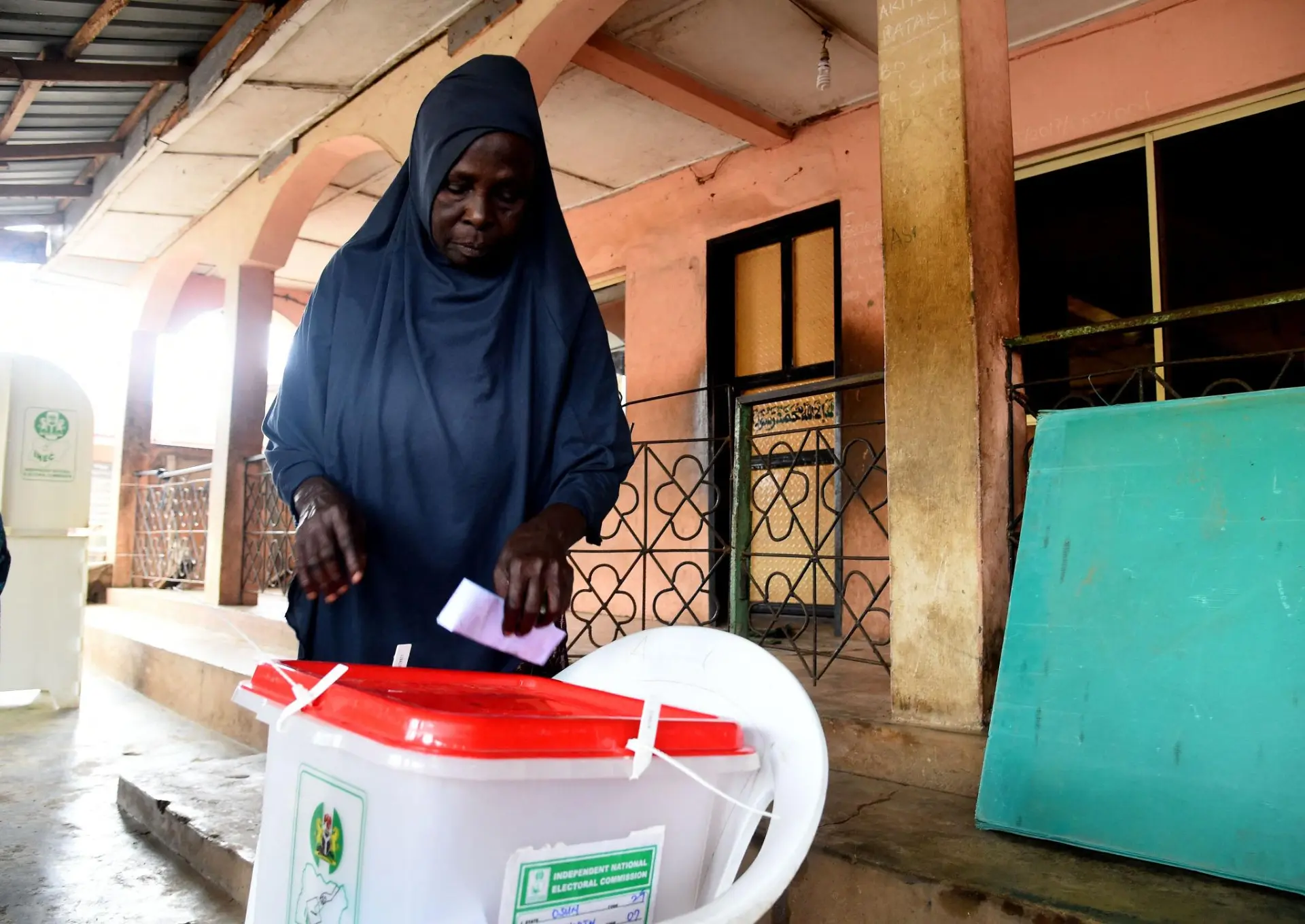 A voter dropping her ballot into a ballot box at a polling unit